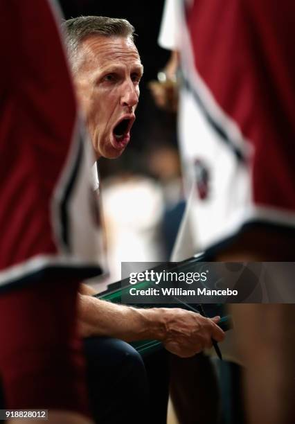 Head coach Mike Dunlap of the Loyola-Marymount Lions huddles with his team during a timeout in the second half against the Gonzaga Bulldogs at...
