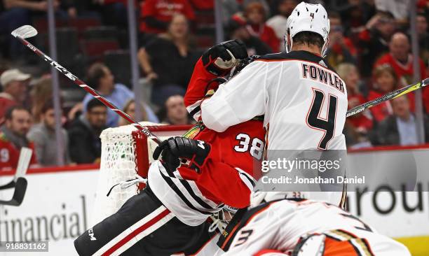 Cam Fowler of the Anaheim Ducks pulls down Ryan Hartman of the Chicago Blackhawks near the goal at the United Center on February 15, 2018 in Chicago,...