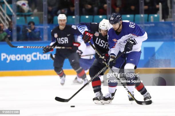 Martin Bakos of Slovakia and John McCarthy of the United States go for the puck during the Men's Ice Hockey Preliminary Round Group B game at...