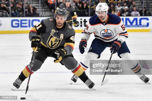 Pierre-Edouard Bellemare of the Vegas Golden Knights handles the puck with Anton Slepyshev of the Edmonton Oilers defending during the game at...