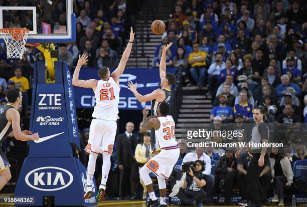 Klay Thompson of the Golden State Warriors goes up to shoot over Alex Len and Troy Daniels of the Phoenix Suns during an NBA basketball game at...