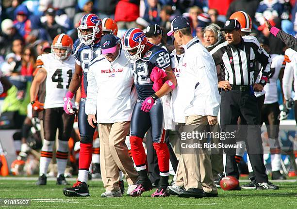Josh Reed of the Buffalo Bills and Bills trainers walk off the field during their NFL game against the Cleveland Browns at Ralph Wilson Stadium on...