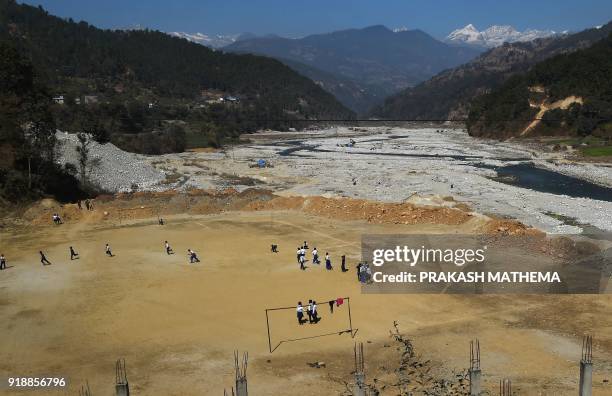 This photograph taken on February 15, 2018 shows Nepali school students playing at a football ground at Bahuneypati, some 70 kilometres northeast of...