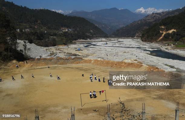 This photograph taken on February 15, 2018 shows Nepali school students playing at a football ground at Bahuneypati, some 70 kilometres northeast of...