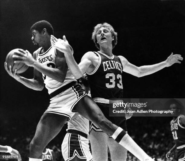 Lakers rookie Magic Johnson rips a rebound from the hands of Boston Celtics rookie Larry Bird during the first half at the Forum on October 28, 1979...