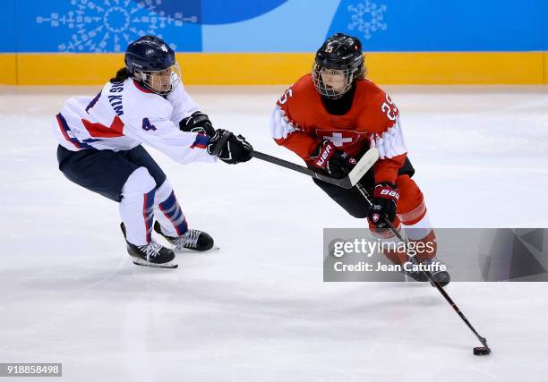 Kim Un Hyang of Korea and Alina Muller of Switzerland during the Women's Ice Hockey Preliminary Round match between Korea and Switzerland on day one...