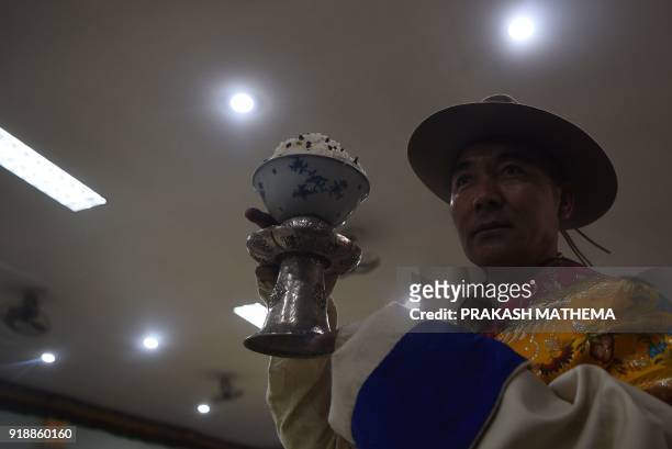 Tibetan in exile makes a food offering to photograph of the Dalai Lama during celebrations marking the Lunar New Year or 'Lhosar' in Kathmandu on...