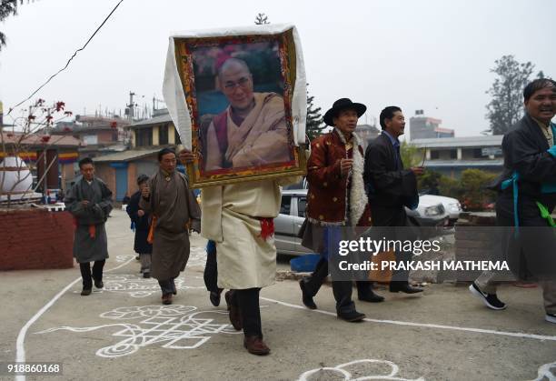 Tibetan in exile carries a photograph of the Dalai Lama during celebrations marking the Lunar New Year or 'Lhosar' in Kathmandu on February 16, 2018....