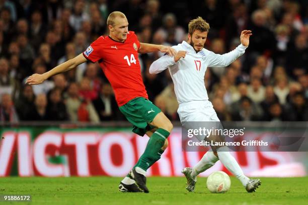 David Beckham of England is tackled by Maxim Bordachev of Belarus during the FIFA 2010 World Cup Qualifying Group 6 match between England and Belarus...