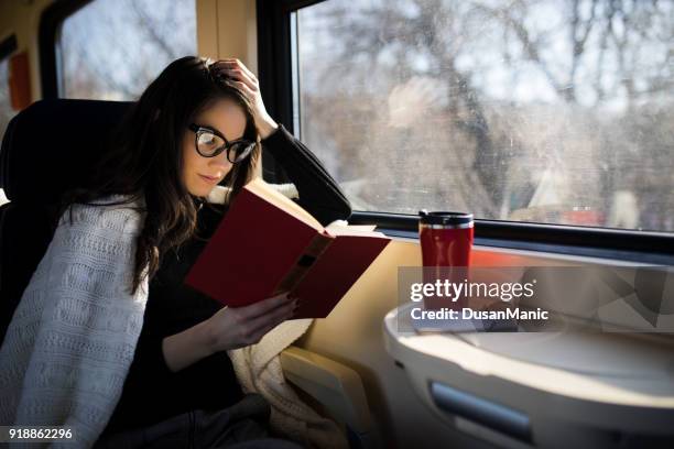 woman reading while traveling with the train commuter journey sitting - travel with book stock pictures, royalty-free photos & images