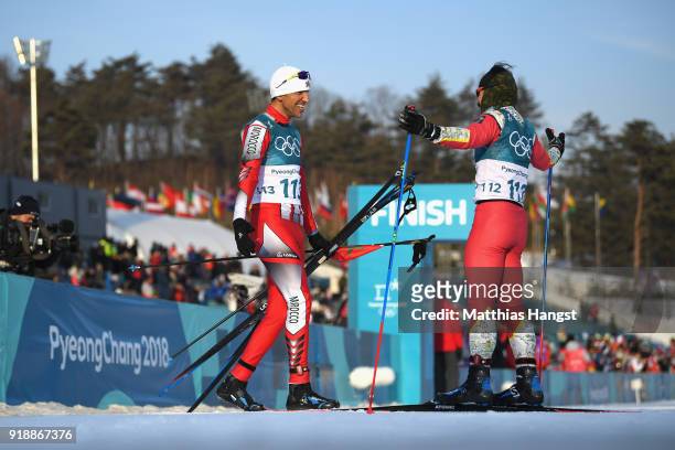 Samir Azzimani of Morocco and Kequyen Lam of Portugal react after crossing the finish line during the Cross-Country Skiing Men's 15km Free at...
