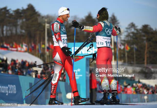 Samir Azzimani of Morocco and Kequyen Lam of Portugal react after crossing the finish line during the Cross-Country Skiing Men's 15km Free at...