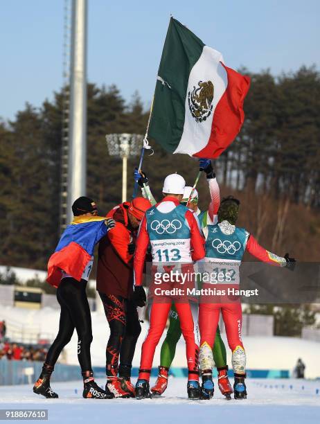 German Madrazo of Mexico holds the flag of Mexico as he crosses the finish line as Sebastian Uprimny of Colombia, Samir Azzimani of Morocco, Pita...