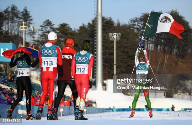 German Madrazo of Mexico holds the flag of Mexico as he crosses the finish line as Sebastian Uprimny of Colombia, Samir Azzimani of Morocco, Pita...