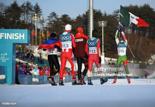 German Madrazo of Mexico holds the flag of Mexico as he crosses the finish line as Sebastian Uprimny of Colombia, Samir Azzimani of Morocco, Pita...