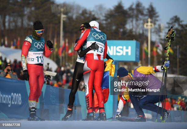 Sebastian Uprimny of Colombia hugs Samir Azzimani of Morocco after crossing the finish line during the Cross-Country Skiing Men's 15km Free at...