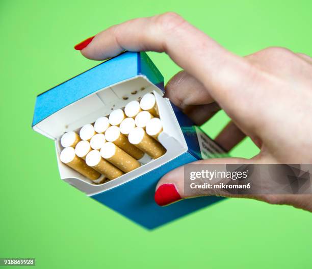 woman's hand taking cigarette from pack - filtre de cigarette photos et images de collection