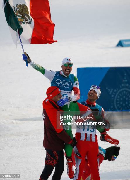 Tonga's Pita Taufatofua and Morocco's Samir Azzimani lift Mexico's German Madrazo onto their shoulders as they celebrate at the finish line in the...