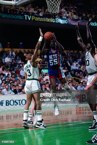 Albert King of the New Jersey Nets goes up for a shot against Dennis Johnson of the Boston Celtics during a game played in 1987 at the Boston Garden...
