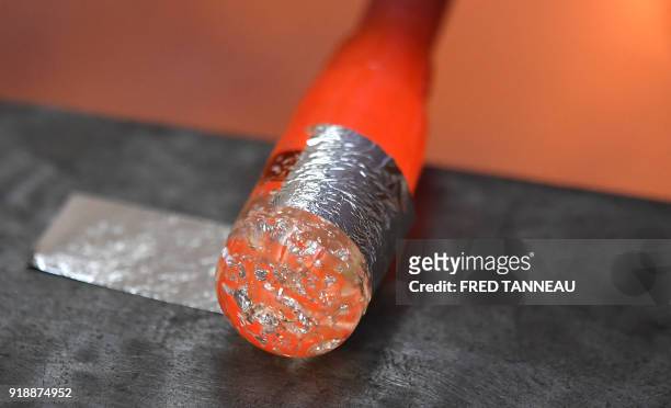 French glassblower puts a leaf of silver on a piece of a door handle at les Verreries de Brehat manufacture in Ile-de-Brehat, an island off the...