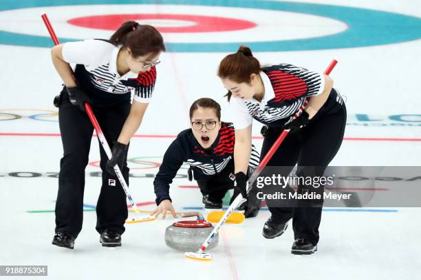 EunJung Kim of Republic of Korea delivers a stone between YeongMi Kim and SeonYeong Kim during their game against Switzerland in the Curling Women's...
