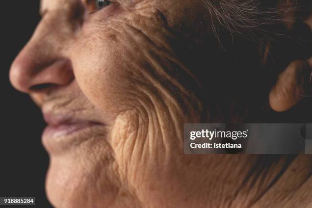 wrinkled face of elderly woman, smiling details - しわ ストックフォトと画像