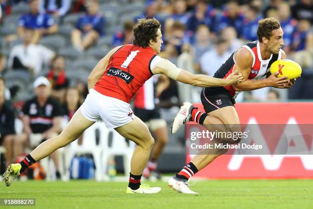 Luke Dunstan of the Saints runs with the ball past Andrew MGrath of the Bombers during the AFLX match between Essendon Bombers and St.Kilda Saints at...