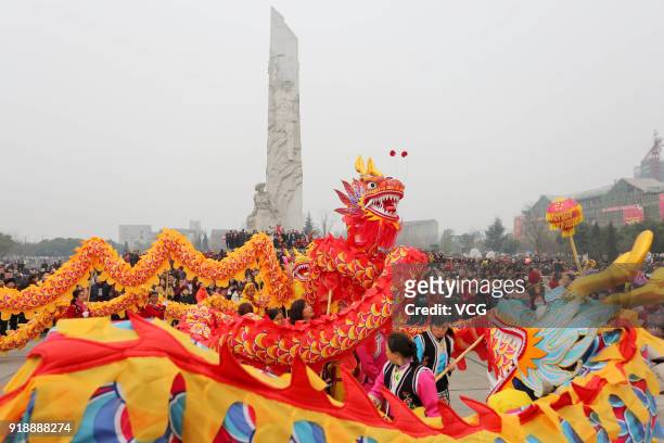 Local residents in festive costumes perform dragon dances together to welcome Lunar New Year on February 16, 2018 in Mianyang, Sichuan Province of...