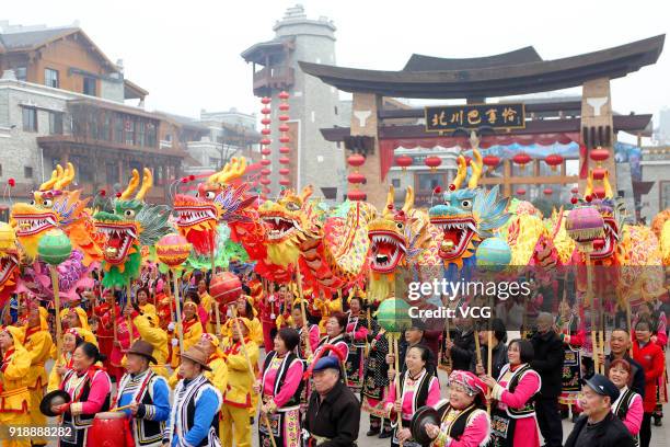 Local residents in festive costumes perform dragon dances together to welcome Lunar New Year on February 16, 2018 in Mianyang, Sichuan Province of...