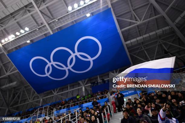 Spectator waves the Russia flag during the men's preliminary round ice hockey match between the Olympic Athletes from Russia and Slovenia during the...