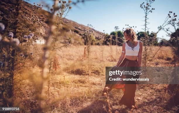 beautiful bohemian woman in red skirt relaxing in field - bohemia stock pictures, royalty-free photos & images