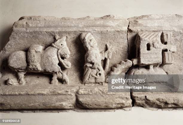 Stone carving depicting milling, museum of Rievaulx Abbey, North Yorkshire, c2013. Showing a miller, mule and mill. Artist Unknown.