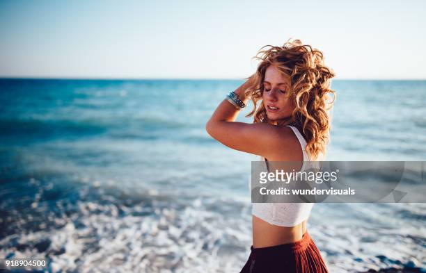 beautiful redhead woman in boho style relaxing at the beach - wavy hair imagens e fotografias de stock