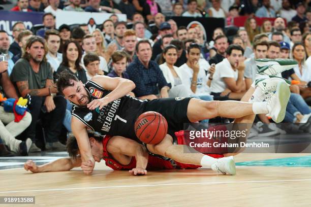 Peter Hooley of Melbourne United and Damian Martin of the Wildcats crash into the crowd during the round 19 NBL match between Melbourne United and...