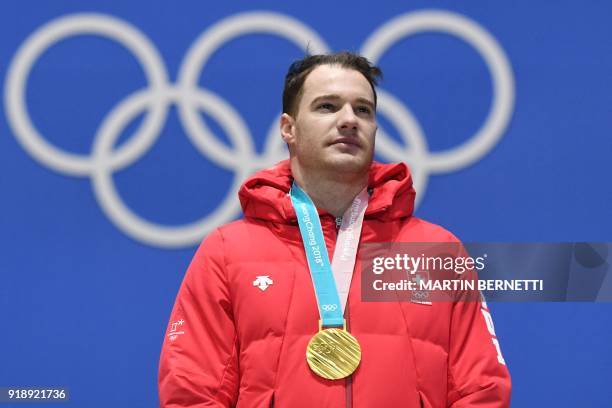 Switzerland's gold medallist Dario Cologna poses on the podium during the medal ceremony for the cross country men's free 15km at the Pyeongchang...