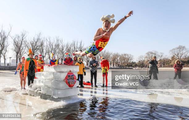 Swimming enthusiast in festive attire jumps into cold river at Beiling Park on the first day of Spring Festival on February 16, 2018 in Shenyang,...