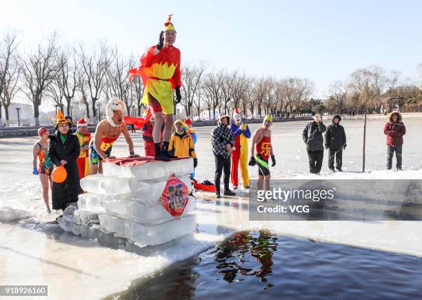 Swimming enthusiast in festive attire jumps into cold river at Beiling Park on the first day of Spring Festival on February 16, 2018 in Shenyang,...