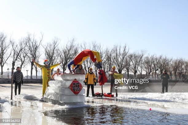 Swimming enthusiast in festive attire jumps into cold river at Beiling Park on the first day of Spring Festival on February 16, 2018 in Shenyang,...