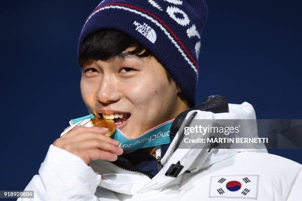 South Korea's gold medallist Yun Sungbin bites his medal on the podium during the medal ceremony for the men's skeleton at the Pyeongchang Medals...