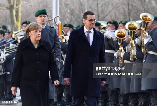 German Chancellor Angela Merkel and Polish Prime Minister Mateusz Morawiecki inspect a military honor guard on February 16, 2018 in front of the...