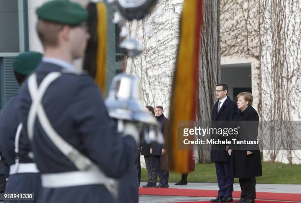 German Chancellor Angela Merkel listens to the national anthems with new Polish Prime Minister Mateusz Morawiecki upon Morawiecki's arrival at the...