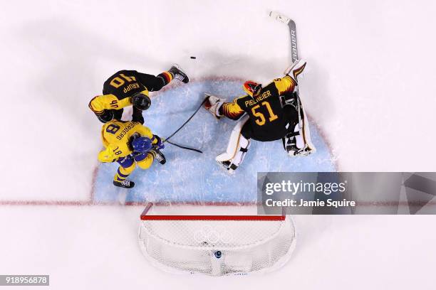 Dennis Everberg of Sweden makes a shot against Timo Pielmeier of Germany during the Men's Ice Hockey Preliminary Round Group B game at Gangneung...