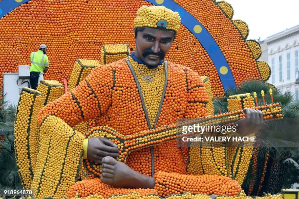 Worker checks a sculpture made of lemons and oranges, on the eve of the 85th Lemon Festival, on February 16, 2018 in Menton, southeastern France. -...