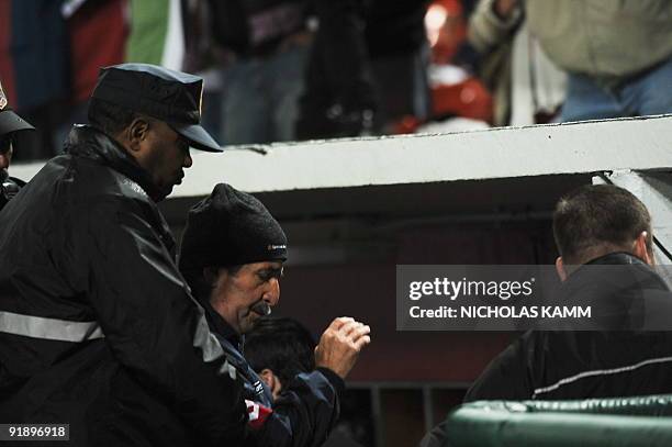 Costa Rican coach Rene Simoes is escorted off the field by security during a 2010 World Cup qualifier against the US at RFK Stadium in Washington on...