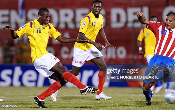 Adrian Ramos kicks the ball to score against Paraguay under the mark of Paulo Da Silva as teammate Jackson Martinez watches during their FIFA World...