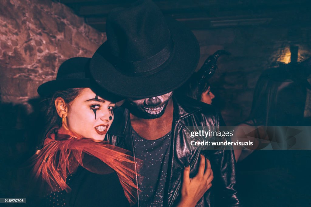 Multi-ethnic couple in Halloween disguise having fun at nightclub party