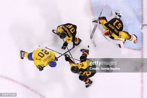 Joel Lundqvist of Sweden makes a shot on Timo Pielmeier of Germany during the Men's Ice Hockey Preliminary Round Group C game at Kwandong Hockey...