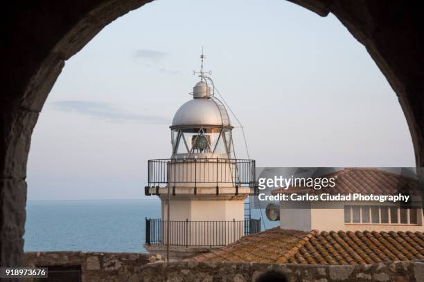 lighthouse of peniscola seen through arch, costa del azahar, castellon, spain - costa_del_azahar stock pictures, royalty-free photos & images