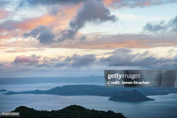 active taal volcano at dusk in the middle of lake taal, itself the result of eruptions over 100,000 years ago, tagaytay, luzon island, philippines - tagaytay stock pictures, royalty-free photos & images