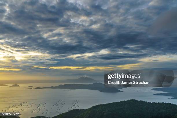 active taal volcano at dawn in the middle of lake taal, itself the result of eruptions over 100,000 years ago, with fish traps in the foreground, tagaytay, luzon island, philippines - tagaytay stock pictures, royalty-free photos & images